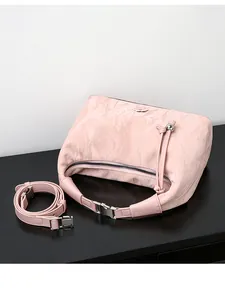 Detailed macro shot of pale pink pleated texture and silver hardware on a shoulder bag