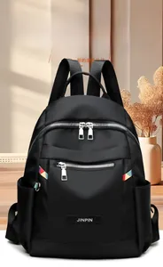 Close-up of black Oxford cloth backpack featuring dual silver zippers and durable texture