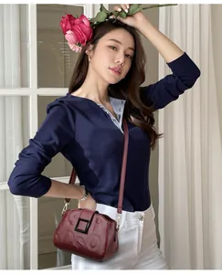 Detailed view of dark red lychee leather bag featuring elegant letter embossing and buckle