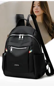 Close-up of black Oxford cloth backpack with metal zippers and minimalist logo detail