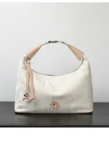 Detail of hobo bag showing marble texture cream leather and silver metal clasp