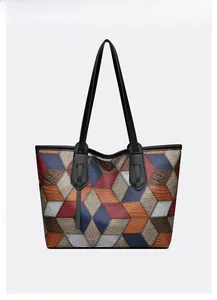 Close-up of geometric patchwork tote bag with crocodile and lychee leather textures