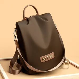Dark brown Oxford fabric women's backpack with dual straps and MTW leather nameplate