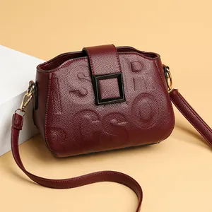 Elegant wine red leather crossbody bag with embossed logo and matte black metal buckle