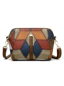 Detailaufnahme der geometrischen Patchwork-Umhängetasche mit Litschitextur