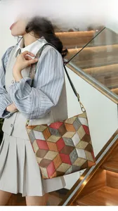 Détail du sac cabas bicolore en cuir gaufré avec une bandoulière tissée chic
