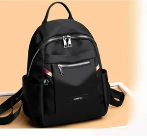 Detail of black oxford backpack showing multi-pocket design and rainbow side strap