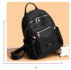 Close-up of black Oxford cloth backpack showing dual front zippers and Jinpin logo