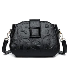 Black pebble grain leather crossbody bag with embossed letters and gold-tone buckle