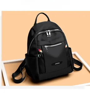 Close-up of black Oxford backpack featuring durable silver zippers and side stripe detail
