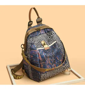 Detail of camouflaged nylon backpack with lettering and versatile metal lock closure