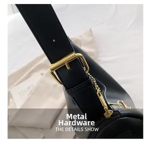 Close-up of premium gold hardware and leather strap detail on a black shoulder bag