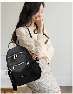 Close-up of black Oxford cloth backpack showing JINPIN logo and silver zippers