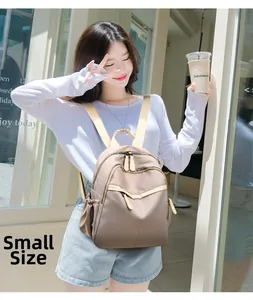 Small size khaki nylon backpack for women shown from the side on an outdoor model