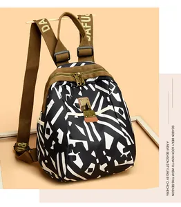 Detail of nylon backpack with black and white abstract pattern and gold twist-lock pocket