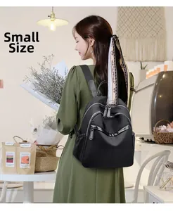 Detail of small black nylon backpack with decorative scarf shown in a lifestyle setting