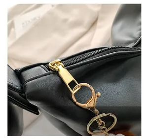 Detail of premium gold zipper with lobster clasp and soft pompom charm on black bag
