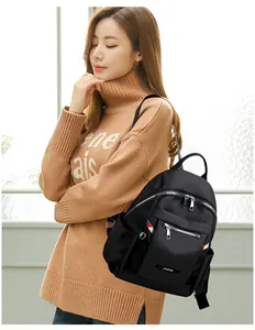 Close-up of black Oxford fabric backpack with multi-zipper layers and side pocket detail