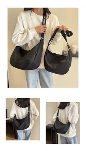 Detail view of black nylon crescent bags in two sizes with FASHION branded straps