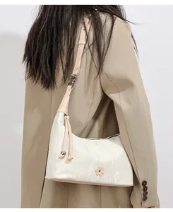 Detail view of cream hobo bag with marble texture and elegant tassels on shoulder