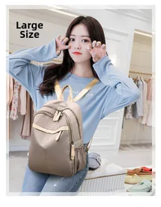 Large khaki nylon backpack with multi-zipper compartments shown on model in shop
