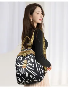Detail of printed wide shoulder strap and metal hardware on nylon backpack for women