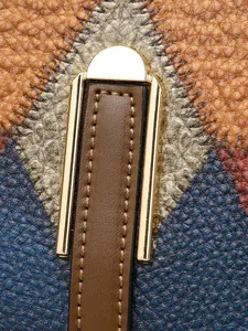 Makroaufnahme von Leder mit Litschi-Struktur und goldfarbenem U-Metallverschluss
