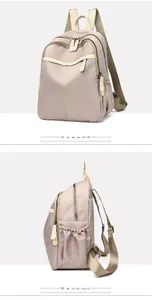 Detail view of khaki nylon backpack showing side pockets and gold zipper accents