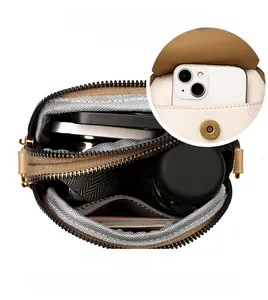 Détails de l'intérieur d'un sac à bandoulière beige avec plusieurs compartiments de rangement