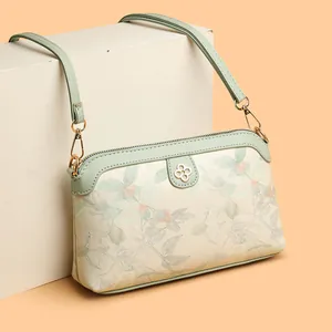 Borsa a tracolla ricamata con fiori beige e verdi e dettaglio quadrifoglio in metallo