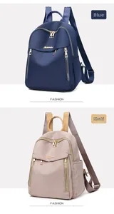 Detail view of khaki and blue nylon backpacks featuring golden zippers and metal logo plaques