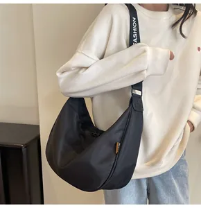 Detail of black nylon half-moon crossbody bag with white FASHION letter strap
