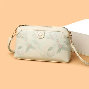 Elegante borsa a tracolla crema con ricami floreali e stemma a quadrifoglio dorato