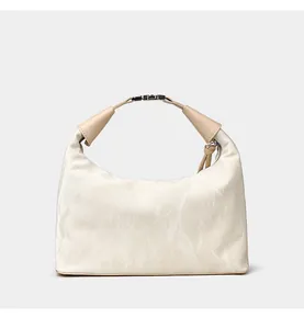 Detail of cream pleated satin handbag featuring khaki leather handle and silver buckle