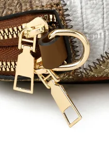 Makro-Detail aus Schlangenmuster-Leder und Vintage-Karo-Nähten mit goldenen Reißverschlüssen