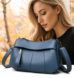 Blaue Umhängetasche aus weichem Leder für Damen in einer natürlichen Outdoor-Lifestyle-Szene
