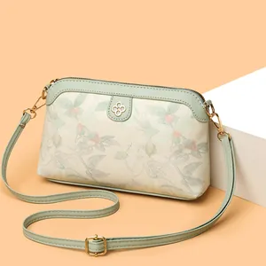 Borsa a tracolla floreale verde chiaro con dettaglio quadrifoglio e tracolla regolabile