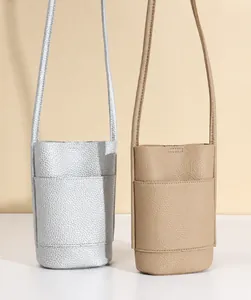 Detail showing litchi grain texture on silver and khaki mini crossbody bucket bags