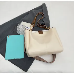 Detail of cream PU leather tote bag showing double straps and internal capacity for tablets