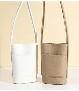 Close-up of white and khaki pebbled leather mini crossbody bags with front pocket