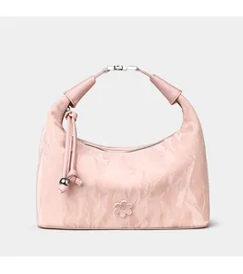 Detailed view of the pleated pink hobo bag with floral accent and metallic sphere charm