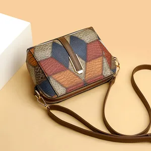 Retro-Umhängetasche aus Leder mit geometrischem Patchwork und goldfarbenem Reißverschluss