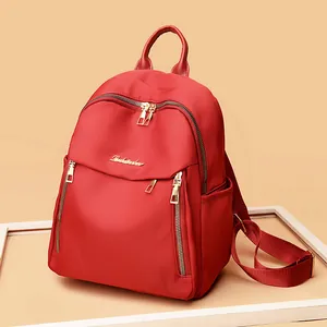Red waterproof oxford fabric backpack for women featuring golden zippers and large capacity