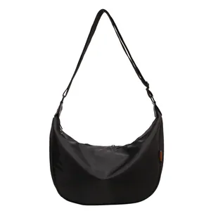Minimalist black nylon hobo crossbody bag with adjustable strap and small woven tag