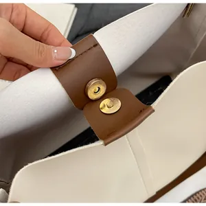 Detailed close-up of tote bag interior featuring gold magnetic snap and premium leather trim