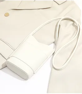Detail shot of white pebbled leather mini crossbody phone bag with fine stitching