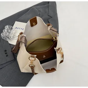 Detail view of large tote bag with inner pouch, printed strap, and metal magnetic clasp