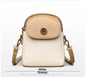 Détail du sac de téléphone en cuir blanc avec ornement marguerite en métal kaki