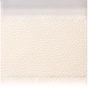 Gros plan sur le cuir souple à texture litchi de ce petit sac bandoulière crème