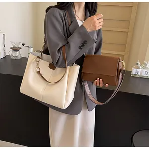 Detail of cream tote and brown crossbody bag set with woven strap and gold chain